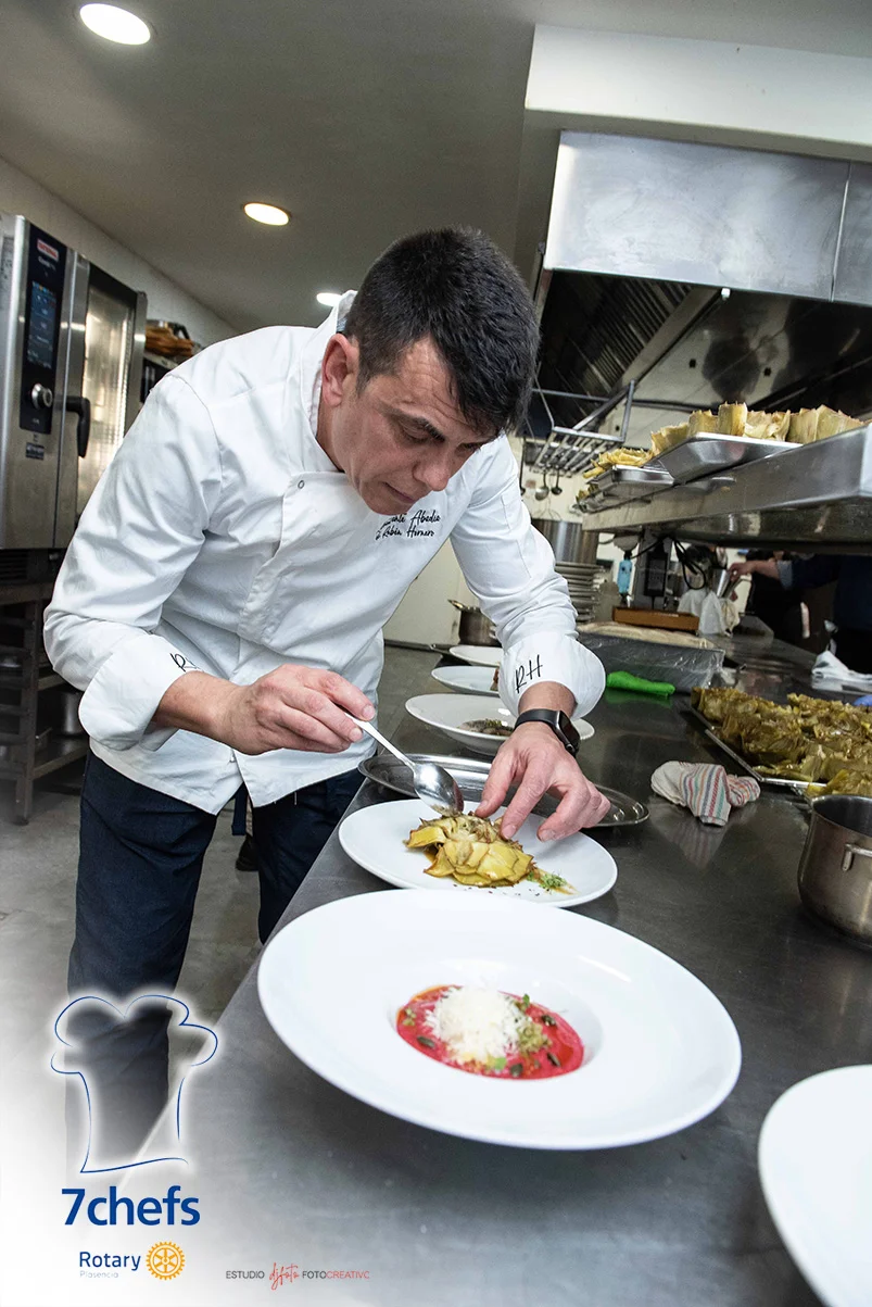 Las manos de un chef dan el último toque a un plato durante la cena de 2025.